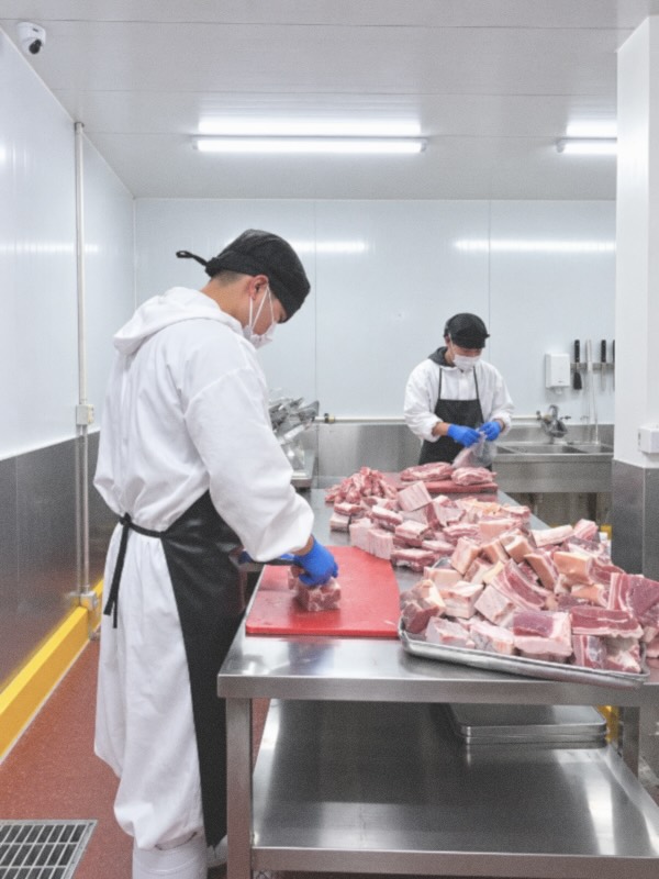 Staff cutting pork belly in the processing room